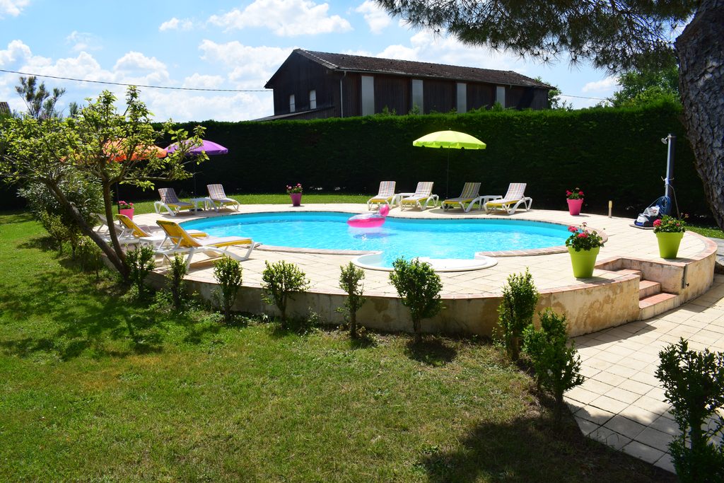 Piscine extérieure du Domaine du Baraillot avec transats et jardin dans le Lot-et-Garonne