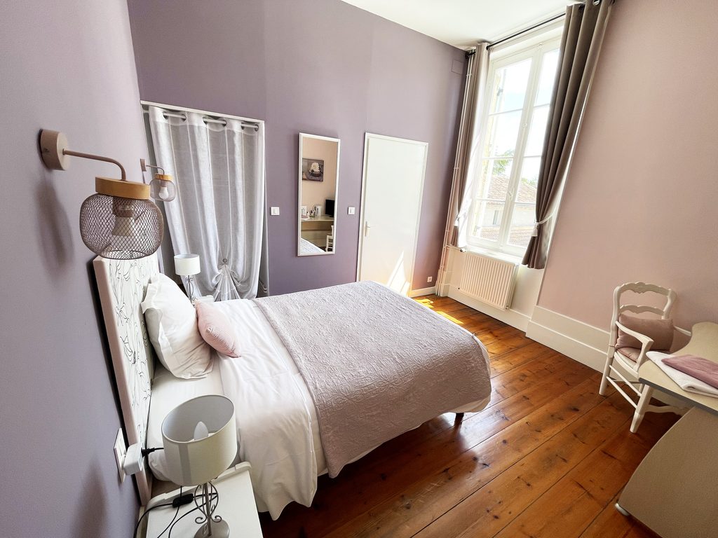 Chambre d'hôtes lumineuse du Domaine du Baraillot, avec parquet ancien et décoration raffinée.